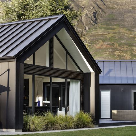 Modern chalet house with a frame facade black metal roof and 